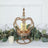 Elegant gold crown candle holder with glass accent and candles.