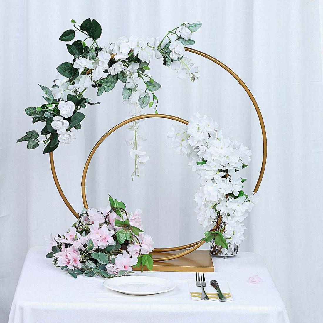 Floral arrangement with gold hoops and pink and white blooms on a table