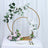 Floral arrangement with gold hoops and pink and white blooms on a table