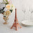 Eiffel Tower replica next to flowers and tableware in a styled setting.