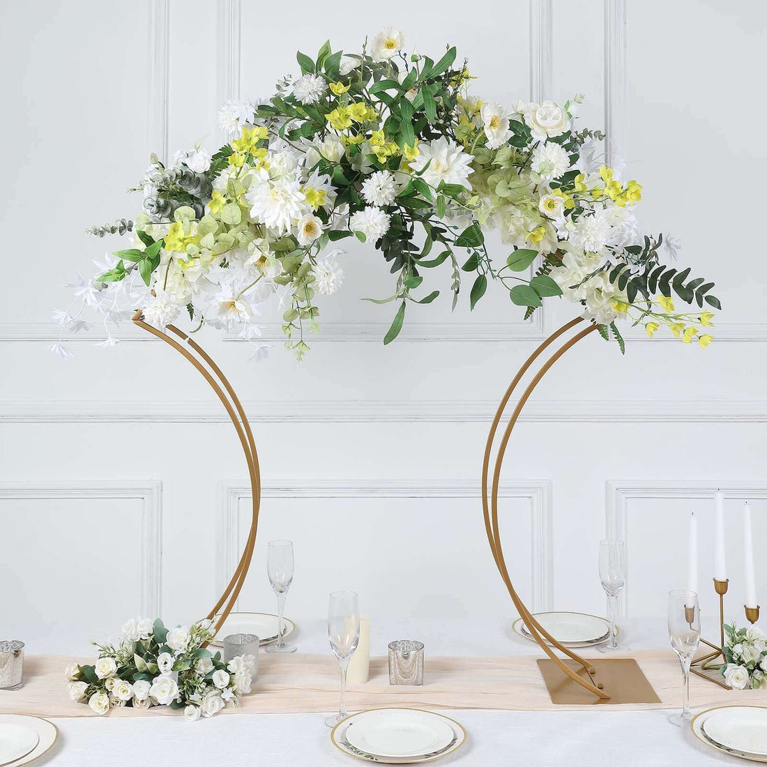 Elegant floral arch centerpiece with white and yellow flowers on a gold stand.