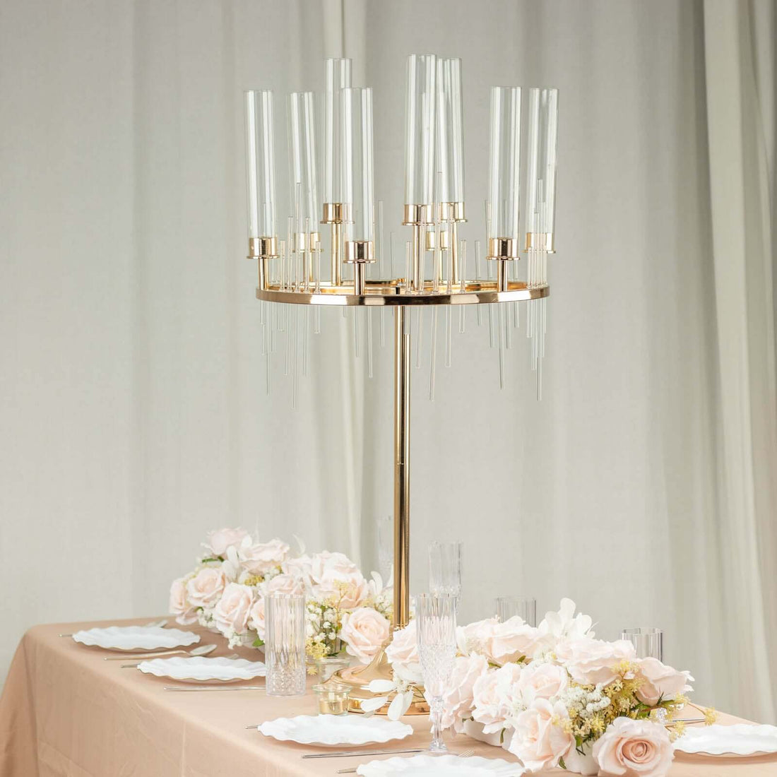 Elegant gold candelabra centerpiece with glass candle holders and floral arrangements.