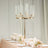 Elegant gold candelabra centerpiece with glass candle holders and floral arrangements.