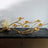 Gold branch candle holder with multiple holders on a black surface.