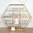 Decorative dessert display with a cake and assorted treats on a geometric shelf.