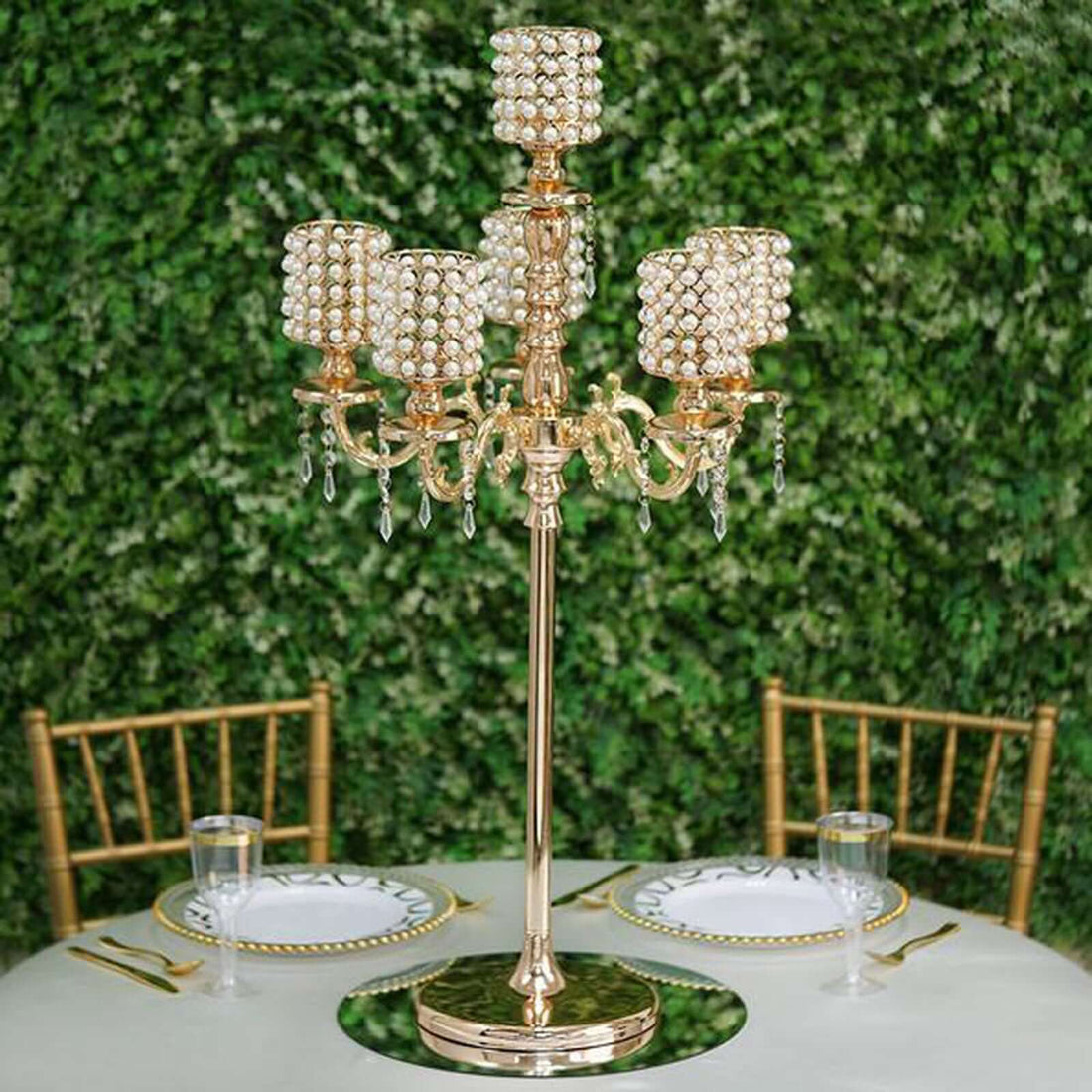 Elegant gold candelabra with crystal accents on a table setting.