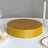 Gold cake stand with textured base on a table setting.