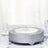 Decorative silver cake stand with intricate floral design on a dining table.