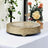 Decorative gold serving tray on a table with flowers in the background.