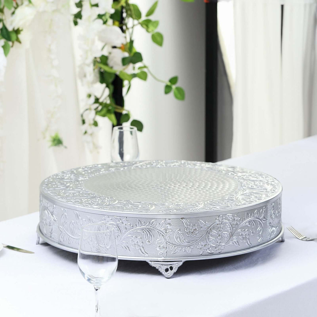 Decorative silver serving tray with intricate design on a table setting.
