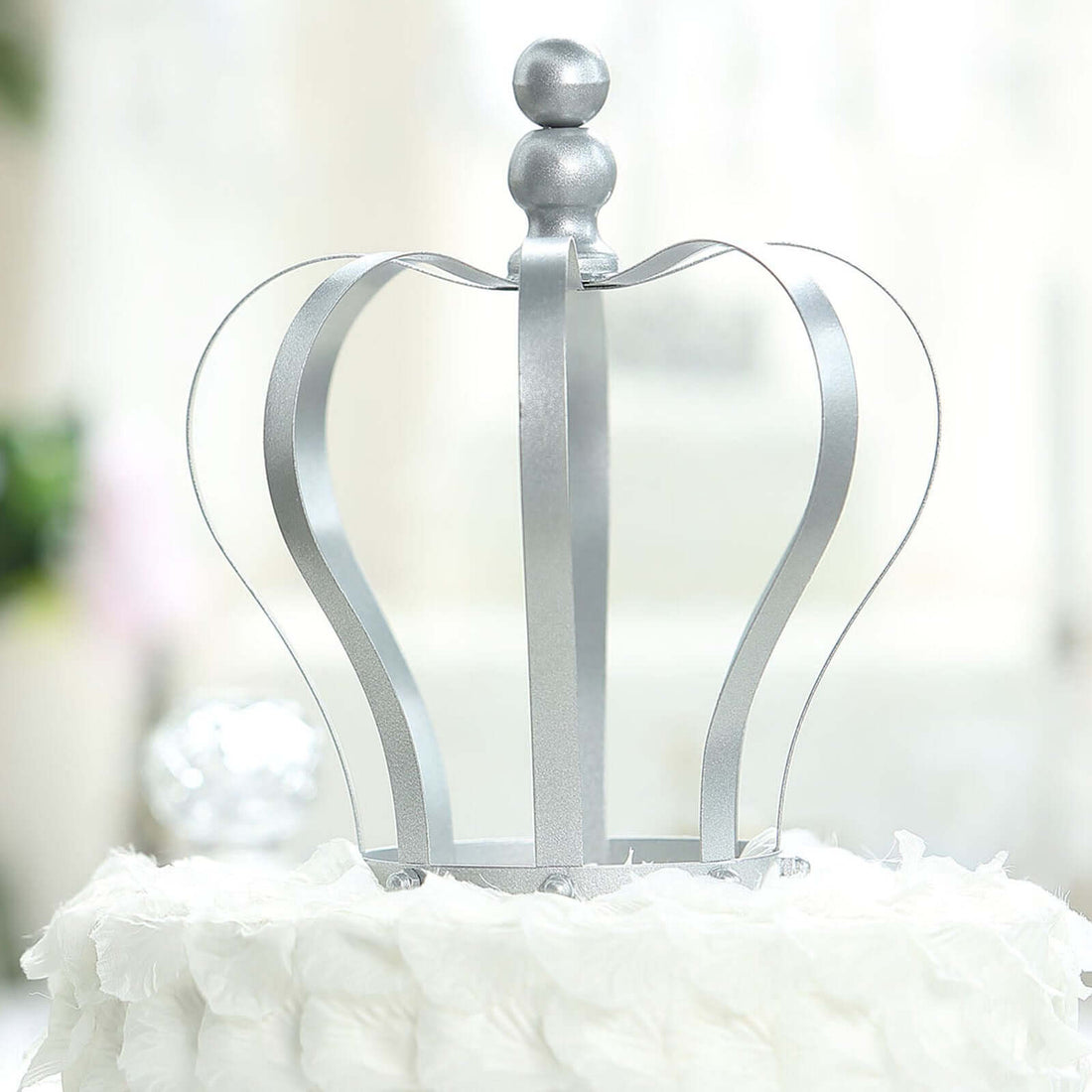 Silver crown decoration for cakes on a white backdrop