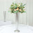 Elegant floral arrangement in a silver cone vase on a table.