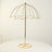 Gold decorative umbrella stand on a white table.
