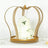 Gold crown cake stand with white floral decoration and a three-tiered cake