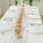 Elegant dining table set with gold floral centerpiece and crystal glassware.