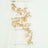 Gold leaf garland draped on a white ladder against a plain background.