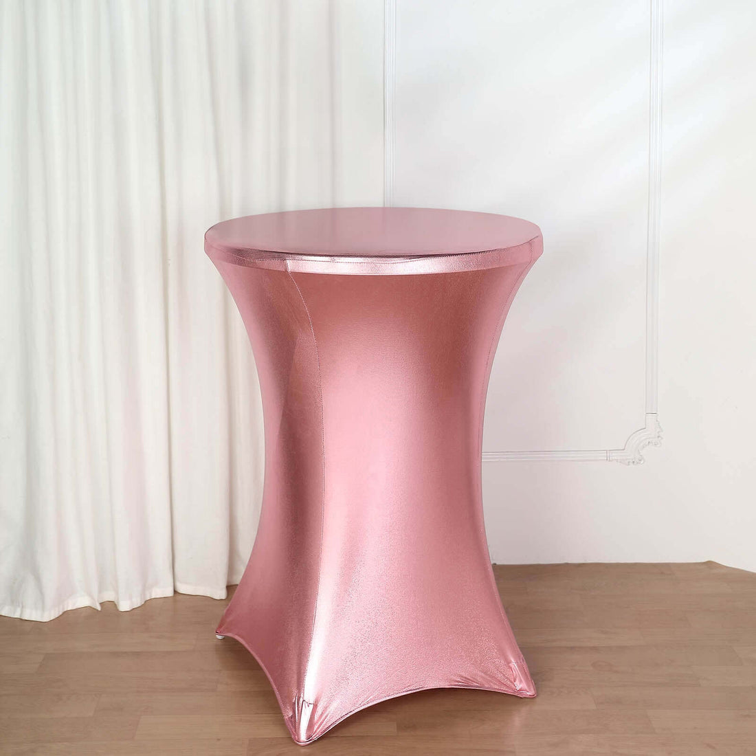 Pink stretch table cover for round tables in a studio setting.