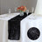 Black table runner on a white table setting with flowers and glassware.