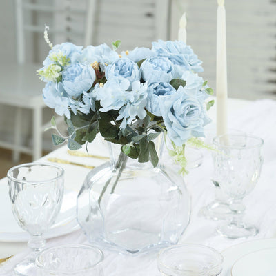 Blue rose bouquet in a clear vase on an elegant dining table.