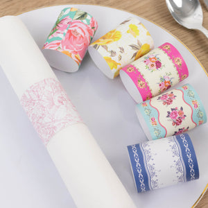 Decorative paper rolls in various floral patterns on a white plate.