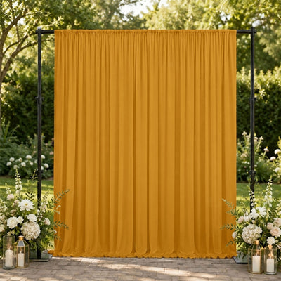 Mustard yellow wedding backdrop curtain with floral arrangements outdoors