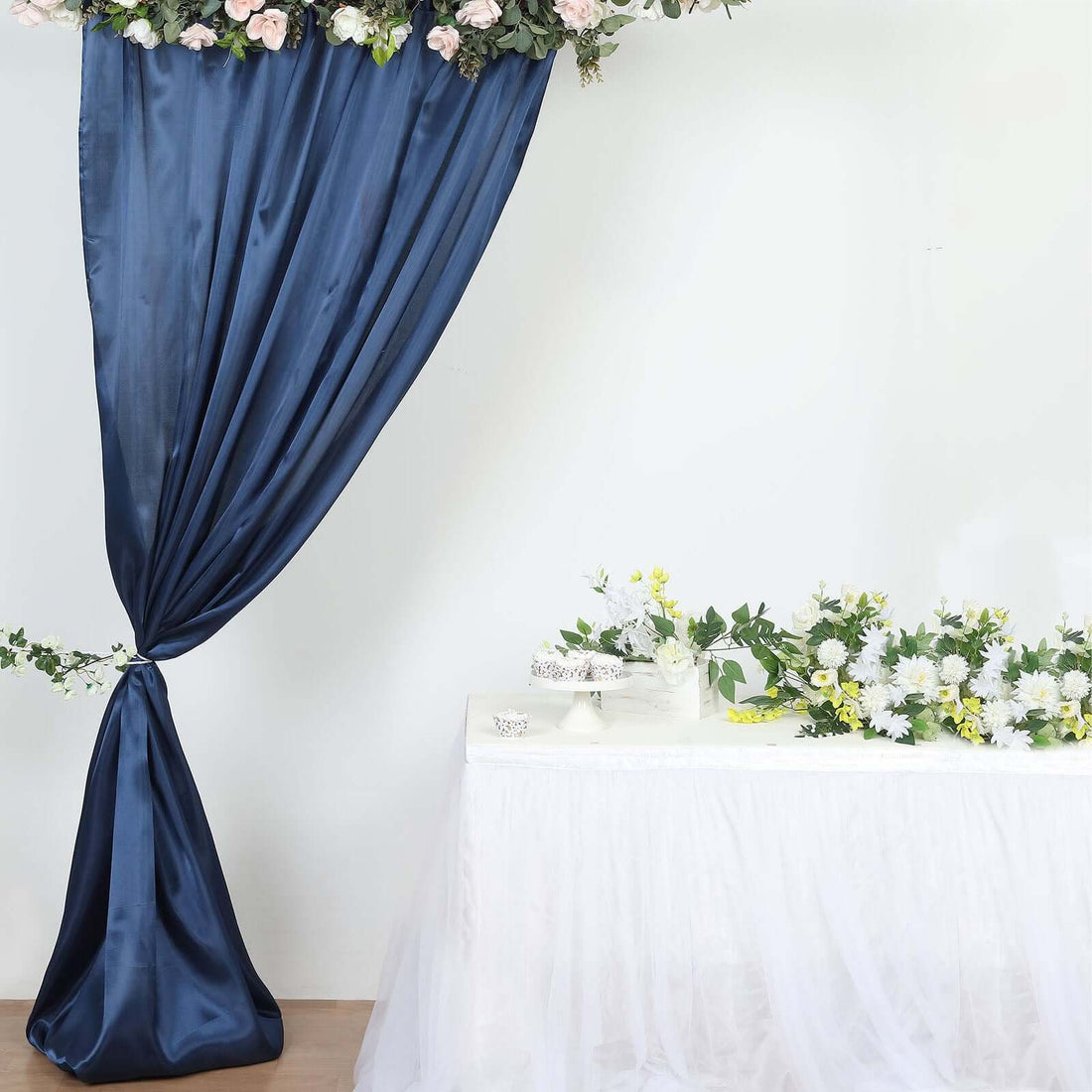 Navy blue curtain backdrop with floral table setup