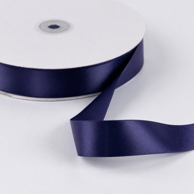 Navy blue satin ribbon roll on white background