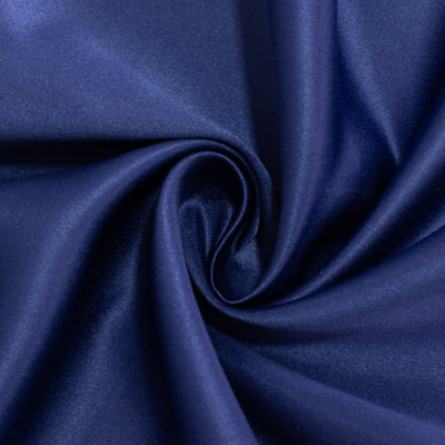Navy blue satin fabric swirl showing smooth texture and sheen. #whtbkgd