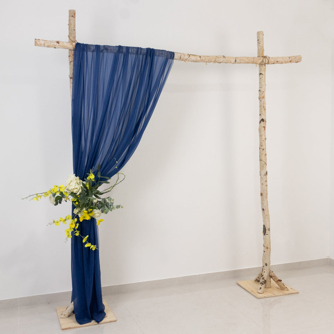 Navy drapery on a rustic wooden frame with floral accents.