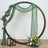 Green draped fabric with floral decor and lanterns in a circular wooden frame.