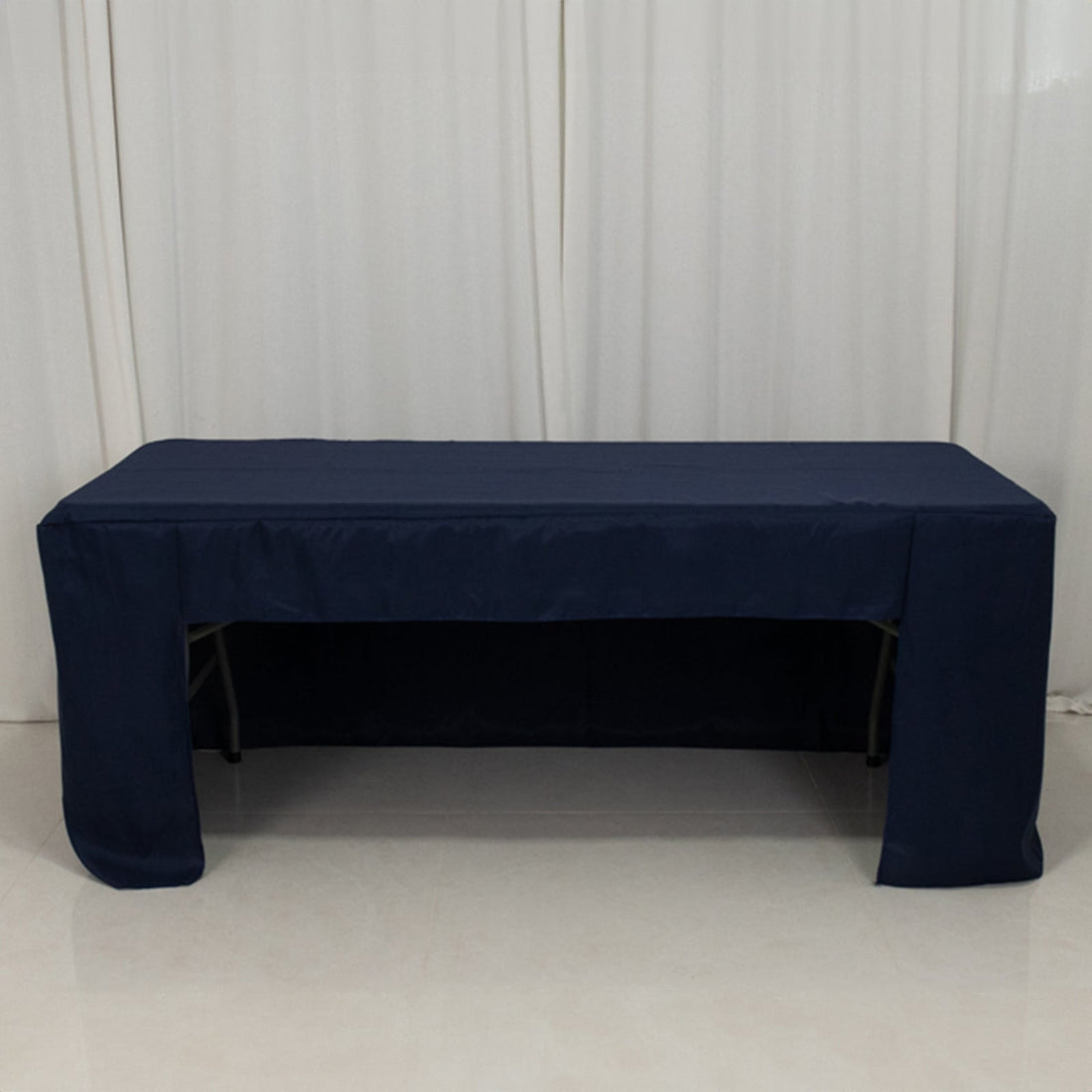 Navy tablecloth draped over a folding table in a studio setting.