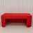 Red tablecloth draped over a folding table in a studio setting.