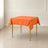 Orange polyester square tablecloth 54"x54" on a dining table.