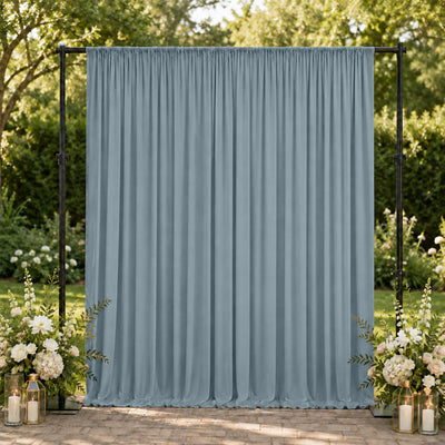 Outdoor wedding backdrop with blue drape, floral arrangements, and lanterns