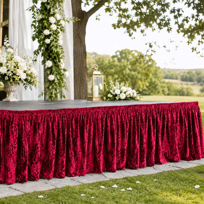 Outdoor wedding table with burgundy velvet table skirt and white floral decor