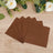 Brown paper napkins stacked on a wooden surface.
