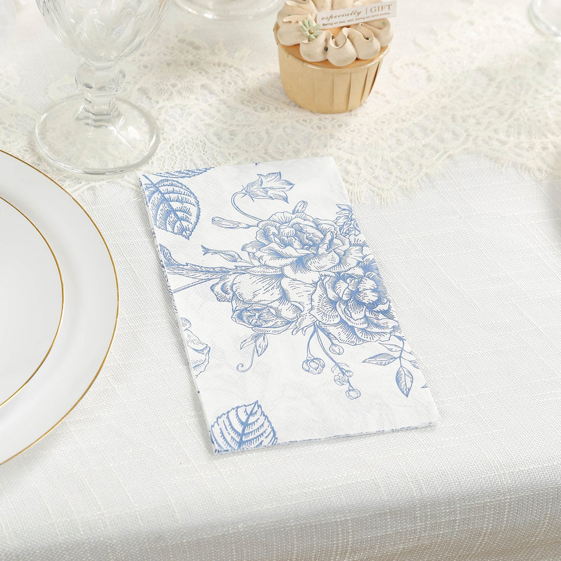 Floral napkin on a dining table setting with dessert