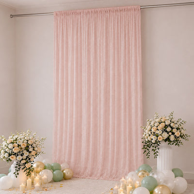 Pastel pink party backdrop with floral arrangements, balloons, and candles