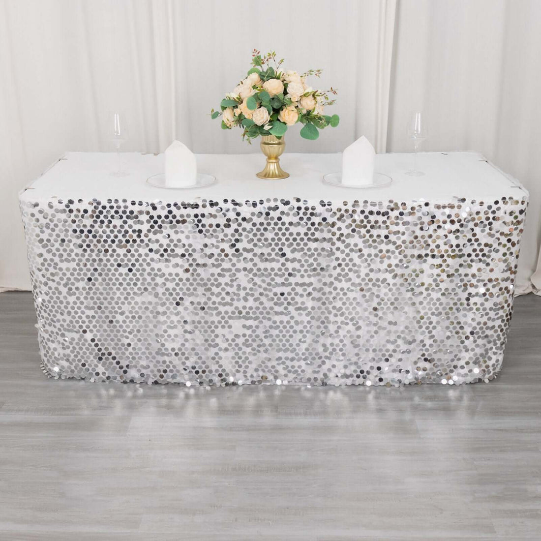 Sparkling silver sequin tablecloth with floral centerpiece and glassware