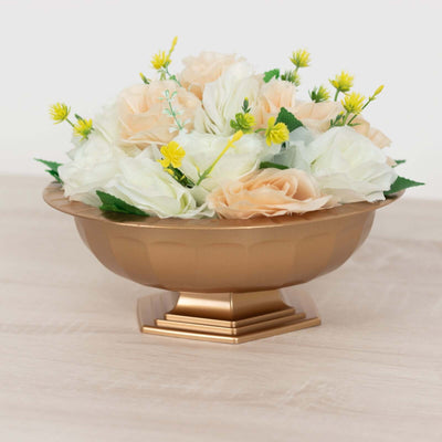 Gold decorative bowl filled with artificial flowers.