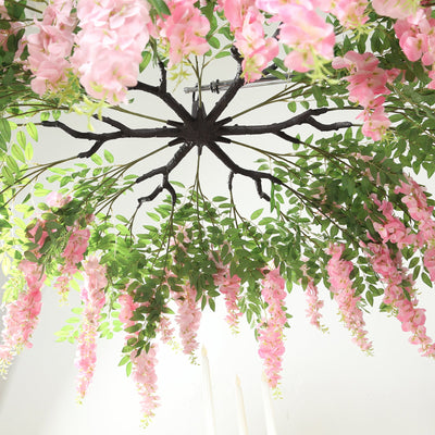Pink floral chandelier with green leaves, showcasing elegant design and vibrant colors.