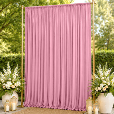 Pink draped wedding backdrop with gold frame and floral arrangements