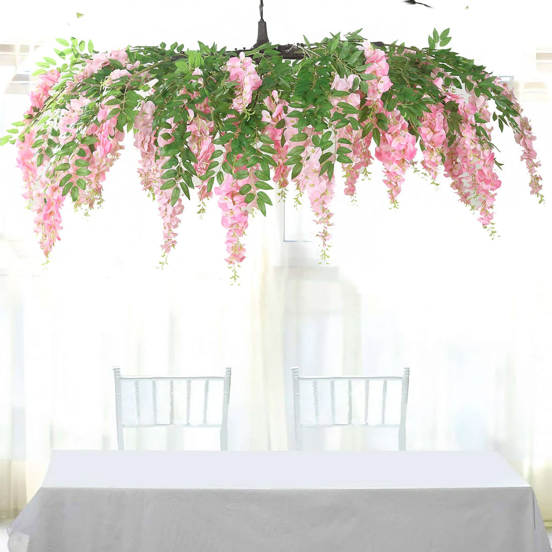 Hanging pink floral chandelier above a table in a bright room.