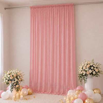 Pink party backdrop with floral arrangements, balloons, and candles for a celebration