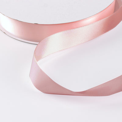 Pink satin ribbon on white background, elegant decorative craft ribbon