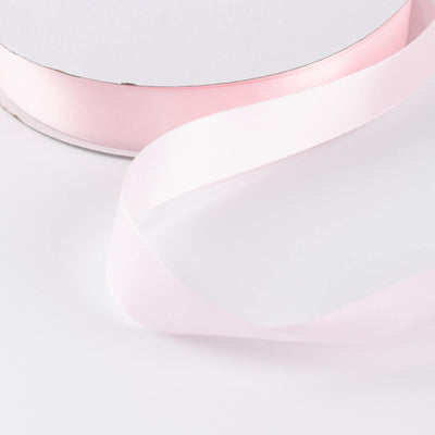 Pink satin ribbon on white background, soft pastel decorative fabric