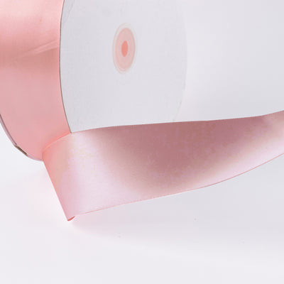 Pink satin ribbon with white gift box on a clean background