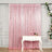 Pink sequin curtain draped elegantly behind a white table with a drink and champagne bottle.