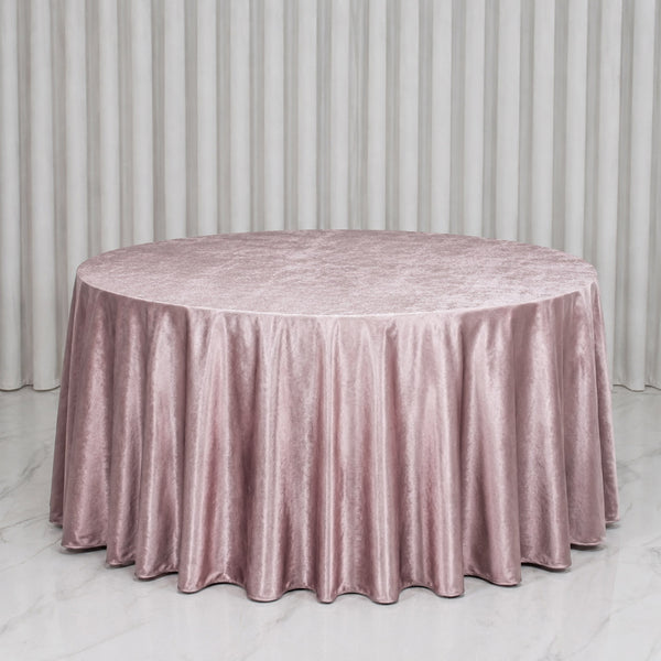 Pink velvet round tablecloth on a table with white curtains backdrop