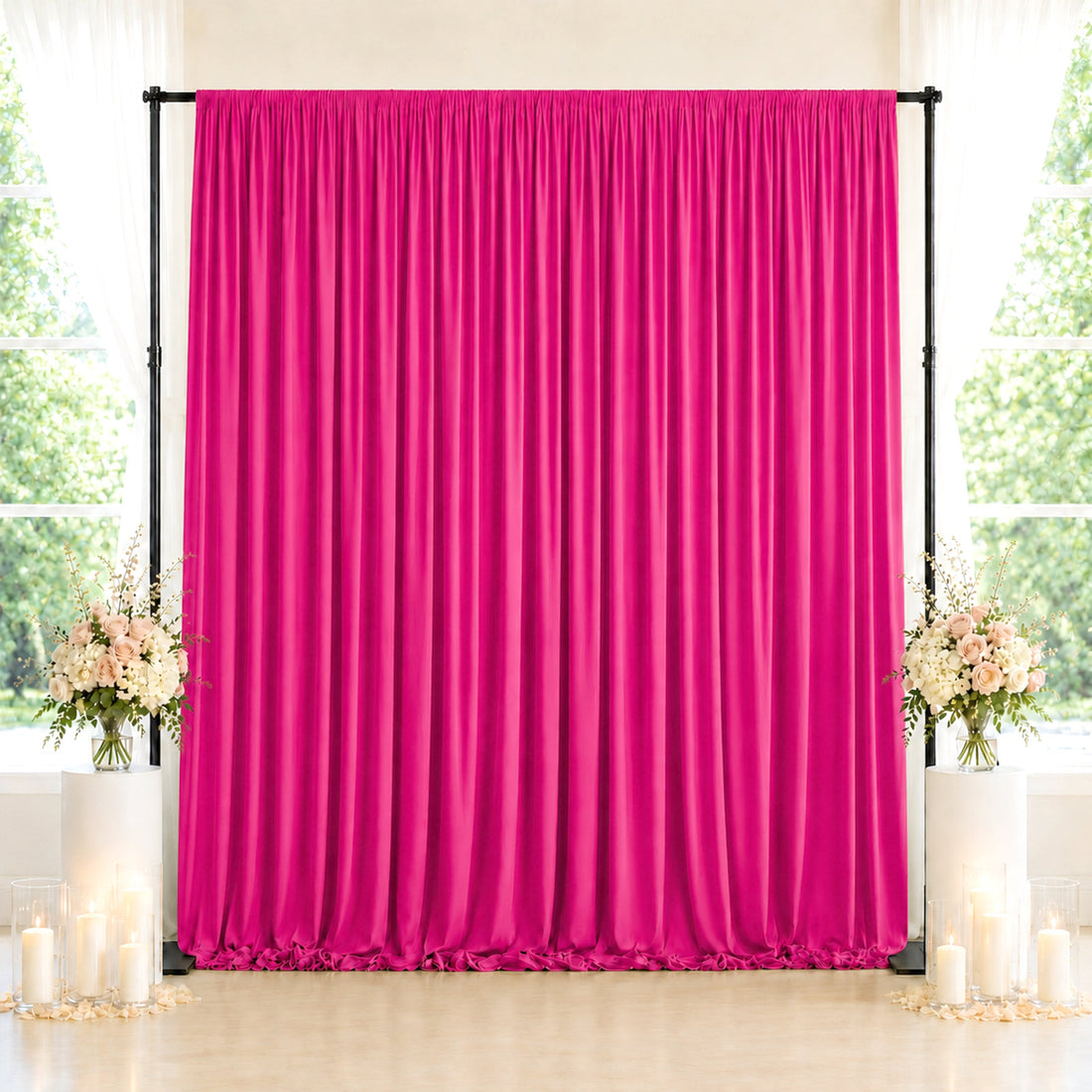 Pink wedding backdrop curtain with floral arrangements and candles